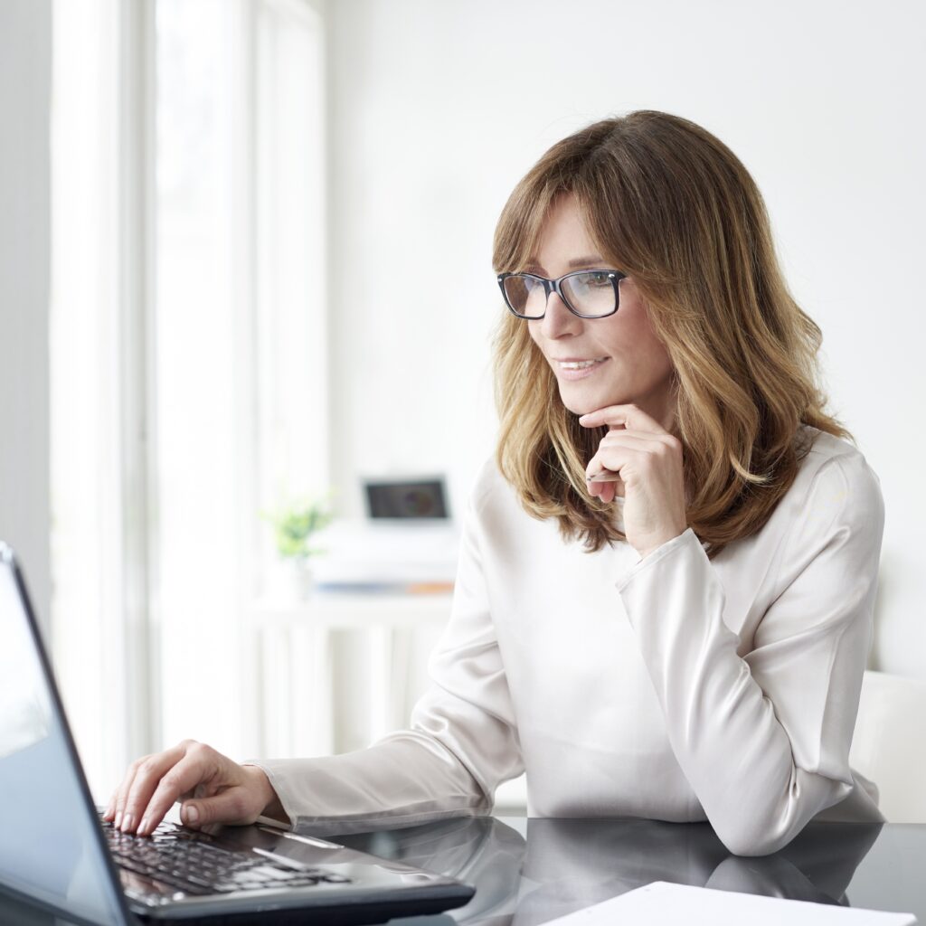 Shot of an attractive mature woman working on laptop in her workstation.
